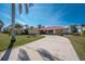 Inviting single-story home featuring a well-manicured front yard, a red metal roof, and palm trees at 35 Sabal Dr, Punta Gorda, FL 33950