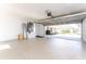 Spacious garage with speckled epoxy flooring, view into the driveway, and access door at 35 Sabal Dr, Punta Gorda, FL 33950