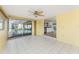 Bright sun room with white tile flooring, ceiling fan, views of pool, and easy access to adjacent kitchen at 35 Sabal Dr, Punta Gorda, FL 33950