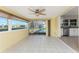 Bright sun room with white tile flooring, ceiling fan, views of pool, and easy access to adjacent kitchen at 35 Sabal Dr, Punta Gorda, FL 33950