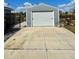 A detached garage stands prominently with a white roll-up door and a clean concrete driveway at 3714 Gulfbreeze Ln, Punta Gorda, FL 33950