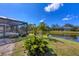 Backyard of home features a screened-in pool, scenic pond, and lush green landscaping at 4 Saint Martin Cir, Englewood, FL 34223