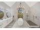 Bright bathroom features dual sinks, freestanding tub, glass enclosed shower, chandelier, and eye-catching stained glass window at 4 Saint Martin Cir, Englewood, FL 34223