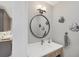 Charming powder room featuring a round mirror, decorative fish, and stylish vanity at 4 Saint Martin Cir, Englewood, FL 34223