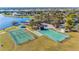 Aerial view of the community tennis court, basketball court, bocce court, playground, lake access, and green spaces at 4383 Mckibben Dr, North Port, FL 34287