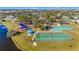 Overhead photograph of the community park featuring tennis courts, a basketball court, a bocce court, a playground, and a lake at 4383 Mckibben Dr, North Port, FL 34287