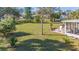 Expansive backyard featuring a screened-in porch, outdoor seating, lush lawn, and a mature palm tree creating a relaxing atmosphere at 4383 Mckibben Dr, North Port, FL 34287