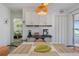 Bright dining area featuring a woven light fixture, white cabinets, and coffee bar at 4383 Mckibben Dr, North Port, FL 34287