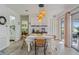 Open concept dining room with modern light fixture, wood-look floors, and sliding door access to the backyard at 4383 Mckibben Dr, North Port, FL 34287