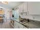 Updated kitchen featuring white cabinets, granite countertops, and a view of the dining area at 4383 Mckibben Dr, North Port, FL 34287