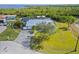 Aerial view of the house with lush lawn, long driveway, screened in pool, and waterway access outlined in white at 5196 Early Ter, Port Charlotte, FL 33981