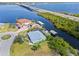 Aerial view of waterfront property with three car driveway, boat dock, pool and spacious lawn, situated on a canal at 5196 Early Ter, Port Charlotte, FL 33981