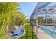 This pool area features a screened-in enclosure and lush greenery at 5196 Early Ter, Port Charlotte, FL 33981