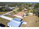 An aerial view of a charming yellow single Gathering home in a quiet neighborhood with beautiful green trees at 8029 Roy Dr, Punta Gorda, FL 33982