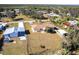 Aerial view of charming yellow single Gathering home in a quiet neighborhood with beautiful green trees at 8029 Roy Dr, Punta Gorda, FL 33982