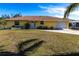 Charming one-story yellow home with a well-manicured lawn and driveway leading to an attached garage at 8029 Roy Dr, Punta Gorda, FL 33982