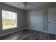 Bedroom featuring wood-look flooring, a window and closet with sliding doors providing ample storage space at 8226 Olsen St, Port Charlotte, FL 33981