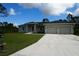 Charming single-story home with a well-manicured lawn, two-car garage, and a modern exterior paint scheme at 8226 Olsen St, Port Charlotte, FL 33981