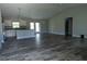 Open living room featuring durable wood-look flooring, modern lighting fixtures, and an open concept design to the kitchen at 8226 Olsen St, Port Charlotte, FL 33981