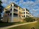 Beautiful condo building with screened balconies, lush landscaping, and sunny skies at 8403 Placida Rd # 408, Placida, FL 33946