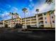 Brightly painted three story condo building with multiple units and external staircases, surrounded by palm trees at 8403 Placida Rd # 408, Placida, FL 33946