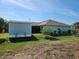 Charming backyard view showcasing an external storage building, lush greenery, and well-maintained landscaping at 9175 Melody Cir, Port Charlotte, FL 33981