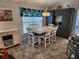 Charming dining area featuring white table, blue accent curtains and gray cabinets at 9175 Melody Cir, Port Charlotte, FL 33981