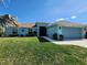 Single-story home with a two-car garage, well-manicured lawn, and mature landscaping, creating a welcoming curb appeal at 9175 Melody Cir, Port Charlotte, FL 33981