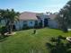 Well-maintained front lawn with palm trees and landscaping, giving this single-story home great curb appeal at 9175 Melody Cir, Port Charlotte, FL 33981