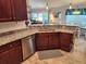 Well-lit kitchen featuring granite countertops, stainless steel dishwasher, and wooden cabinetry at 9175 Melody Cir, Port Charlotte, FL 33981