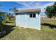 Well-maintained backyard storage shed offering convenience and extra space, painted a matching light blue color at 9175 Melody Cir, Port Charlotte, FL 33981