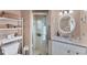 Well-lit bathroom featuring a tiled shower, vanity with marble countertop, and a round mirror at 92 Circlewood Dr # B3-1, Venice, FL 34293