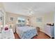 Cozy bedroom featuring nautical themed bedding, ceiling fan, and wood flooring at 92 Circlewood Dr # B3-1, Venice, FL 34293