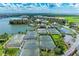 Beautiful aerial view of community buildings, tennis courts, landscaping, and lake views at 93 Vivante Blvd # 9336, Punta Gorda, FL 33950