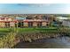 Wide aerial shot of a community featuring condos, a pool, and serene lake views at 93 Vivante Blvd # 9336, Punta Gorda, FL 33950