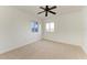 Neutral bedroom showcasing two windows, plush carpeting, and a modern ceiling fan at 93 Vivante Blvd # 9336, Punta Gorda, FL 33950