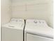 Convenient laundry room with white washer and dryer units and overhead storage shelf at 93 Vivante Blvd # 9336, Punta Gorda, FL 33950