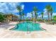 Beautiful community pool with a zero entry, palm trees, and plenty of lounge chairs at 93 Vivante Blvd # 9336, Punta Gorda, FL 33950