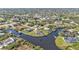 Panoramic aerial view of a home on the water with a dock, surrounded by canals and lush greenery in a vibrant community at 9428 Bandera Ln, Port Charlotte, FL 33981