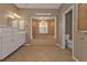 Bathroom featuring a bathtub, vanity with sink, large mirror, decorative lighting, and a separate toilet room at 9428 Bandera Ln, Port Charlotte, FL 33981