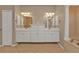 Bathroom featuring double sinks, a large mirror, decorative lighting, a bathtub, and a separate toilet room at 9428 Bandera Ln, Port Charlotte, FL 33981