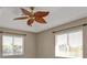 Bright bedroom with an ornate leaf ceiling fan and two windows at 9428 Bandera Ln, Port Charlotte, FL 33981