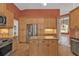 Kitchen featuring stainless steel appliances, wood cabinets, and granite countertops at 9428 Bandera Ln, Port Charlotte, FL 33981