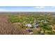 Wide aerial view of a residential area with houses nestled among green trees under a blue sky with a few clouds at 9505 Delray Dr, New Port Richey, FL 34654