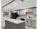 Well-lit kitchen featuring gray cabinetry, an island, and modern appliances at 9505 Delray Dr, New Port Richey, FL 34654