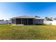 Large backyard featuring a screened in porch and freshly cut lawn at 11176 3Rd Ave, Punta Gorda, FL 33955