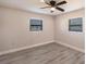 Cozy bedroom with wood-look flooring, neutral walls, a ceiling fan and natural light through a window at 11176 3Rd Ave, Punta Gorda, FL 33955