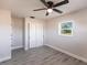 Bedroom with gray plank flooring, ceiling fan, closet with shelving and a bright window at 11176 3Rd Ave, Punta Gorda, FL 33955