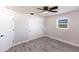 Bedroom features gray plank flooring, ceiling fan, closet, and a window for natural light at 11176 3Rd Ave, Punta Gorda, FL 33955