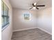 Bedroom featuring plank flooring, ceiling fan, and dual windows for ample natural light at 11176 3Rd Ave, Punta Gorda, FL 33955